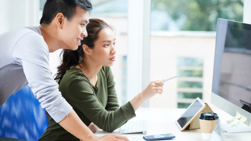 a man and woman looking at a tablet